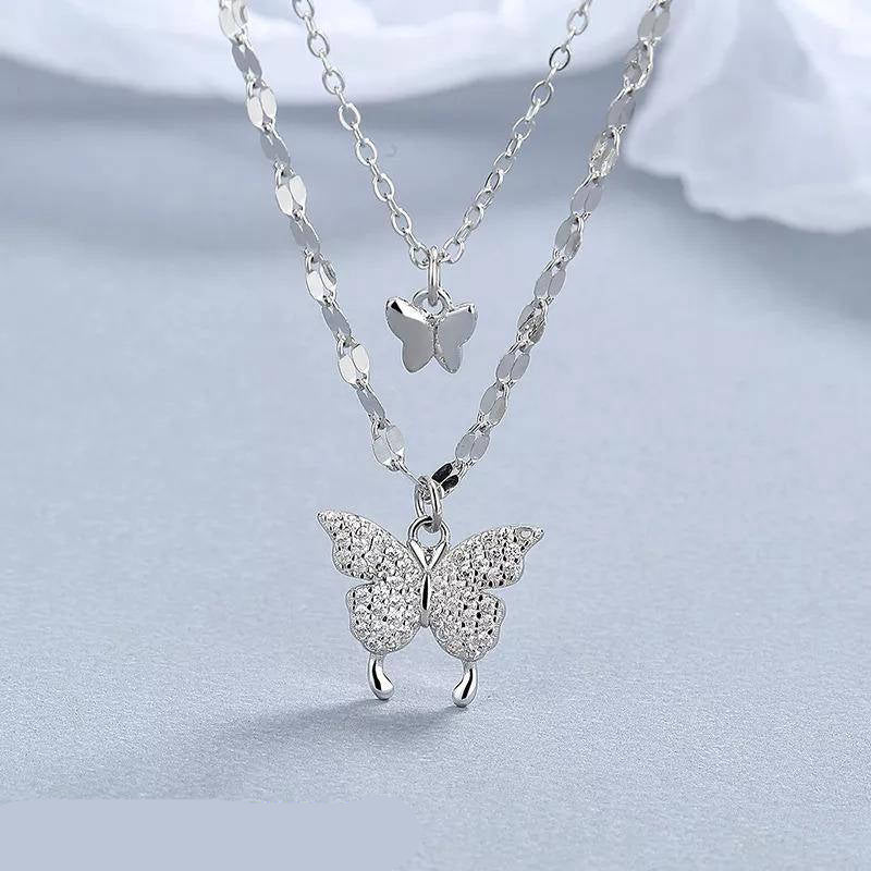 Silver butterfly necklace on a light gray background