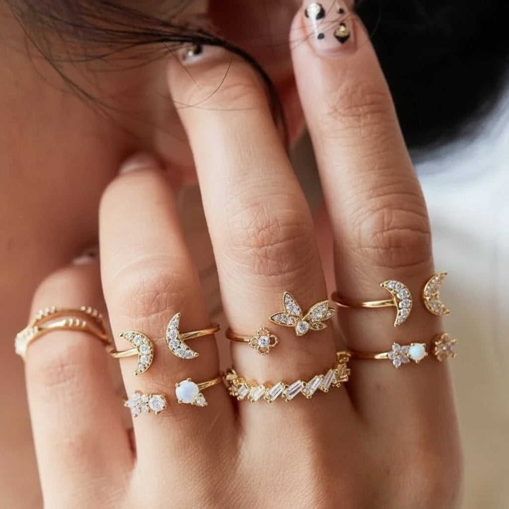 Close-up of a hand wearing multiple gold rings with various designs.